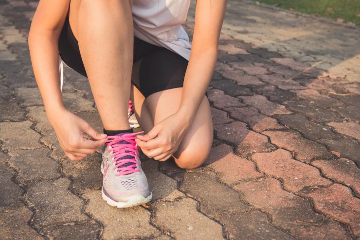 Running Shoes – Woman Tying Shoe Laces. Closeup of Female Sport Woman Tying Shoe Laces